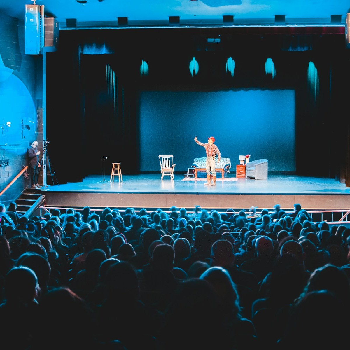Packed theatre audience watching a live stage show